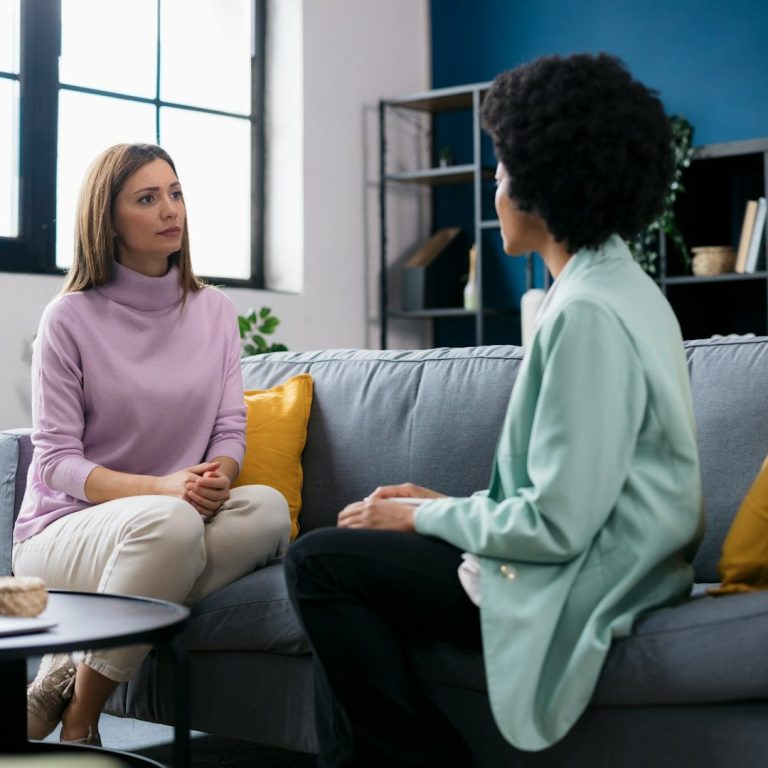 Dos personas conversando en sofá